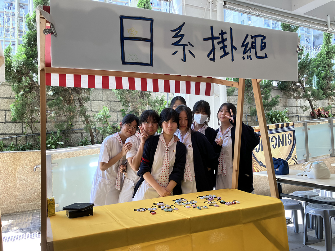 A person standing in front of a bannerDescription automatically generated